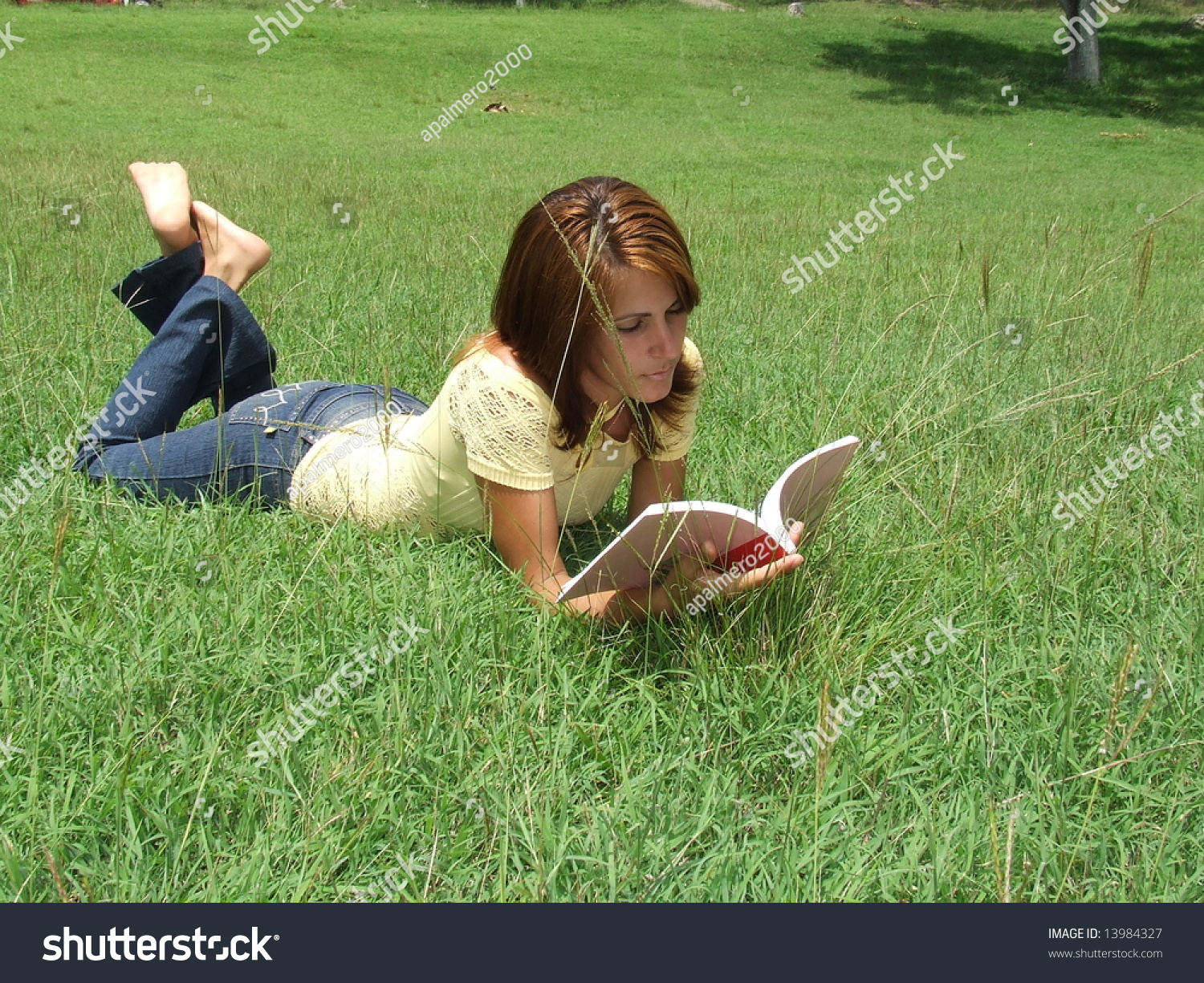 Beautiful Girl Reading A Book While Laying On The Grass Stock Photo ...