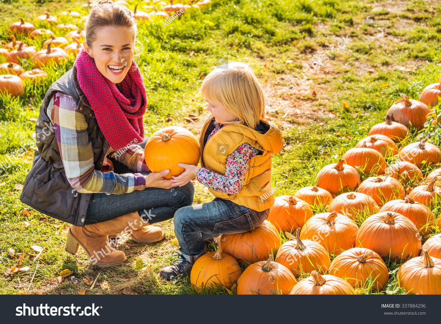 Beautiful Smiling Woman And Child Choosing A Pumpkin On A Pumpkin Patch ...