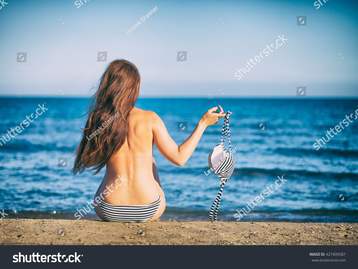 ビキニを持つトップレスのビーチの美しい女性 の写真素材 今すぐ編集