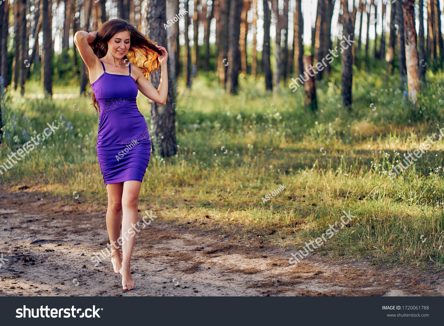 https://image.shutterstock.com/z/stock-photo-beautiful-woman-walks-barefoot-in-a-short-blue-dress-walks-in-the-park-at-sunset-1720061788.jpg