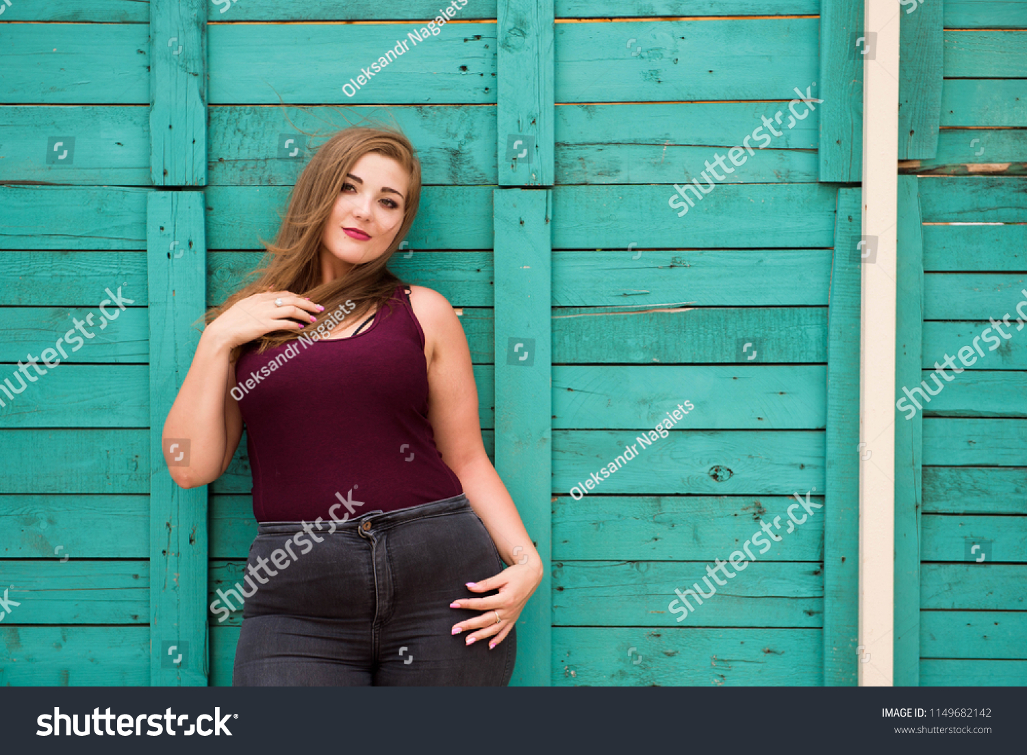 beautiful-woman-wearing-ripped-jeans-standing-stock-photo-1149682142