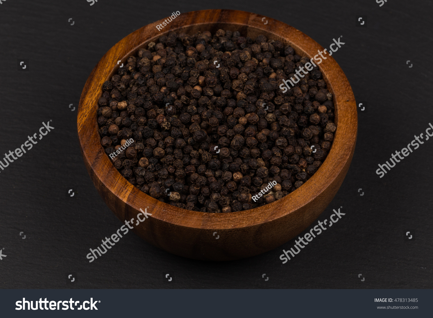 Black Peppercorn In A Wooden Spoon Isolated On White