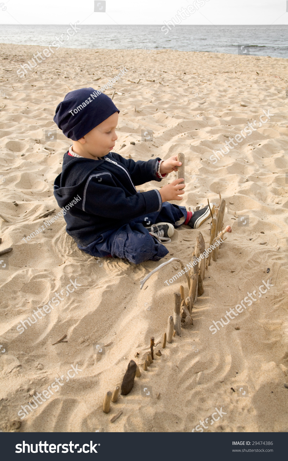 boy on beach building fence sticks stock photo 29474386 shutterstock