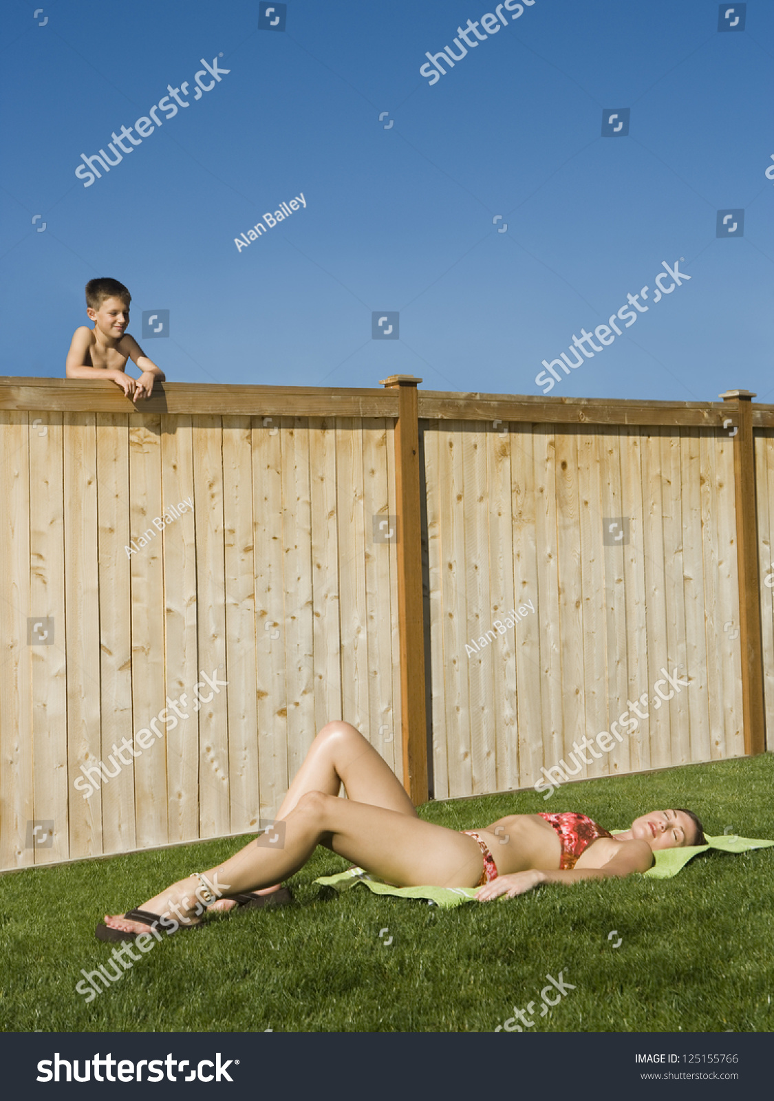 Boy Peeping Over Fence Woman Sunbathing Stock Photo Edit Now