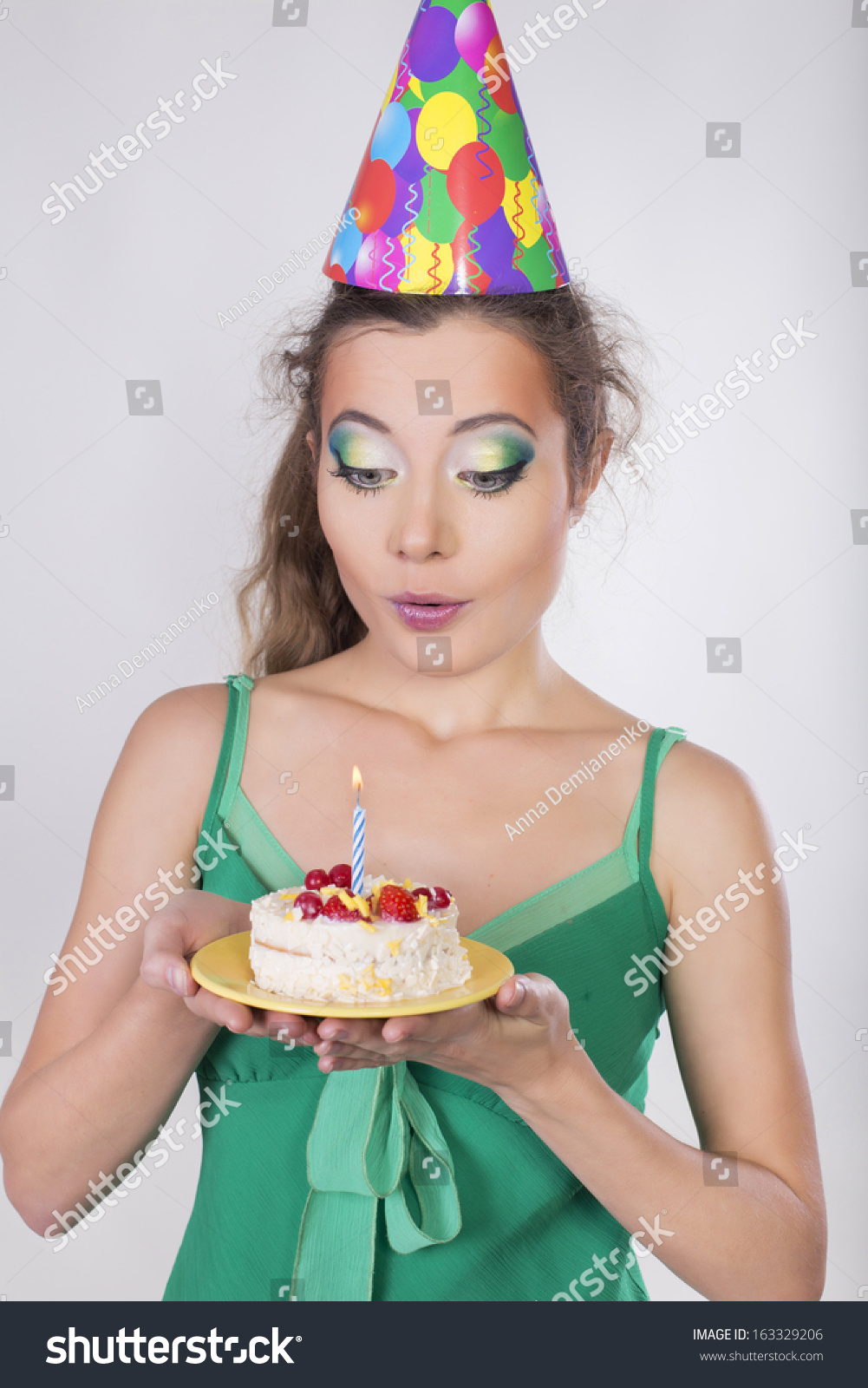 Brunette Woman In A Birthday Cap Holding A Cake And Smile Looking On It ...