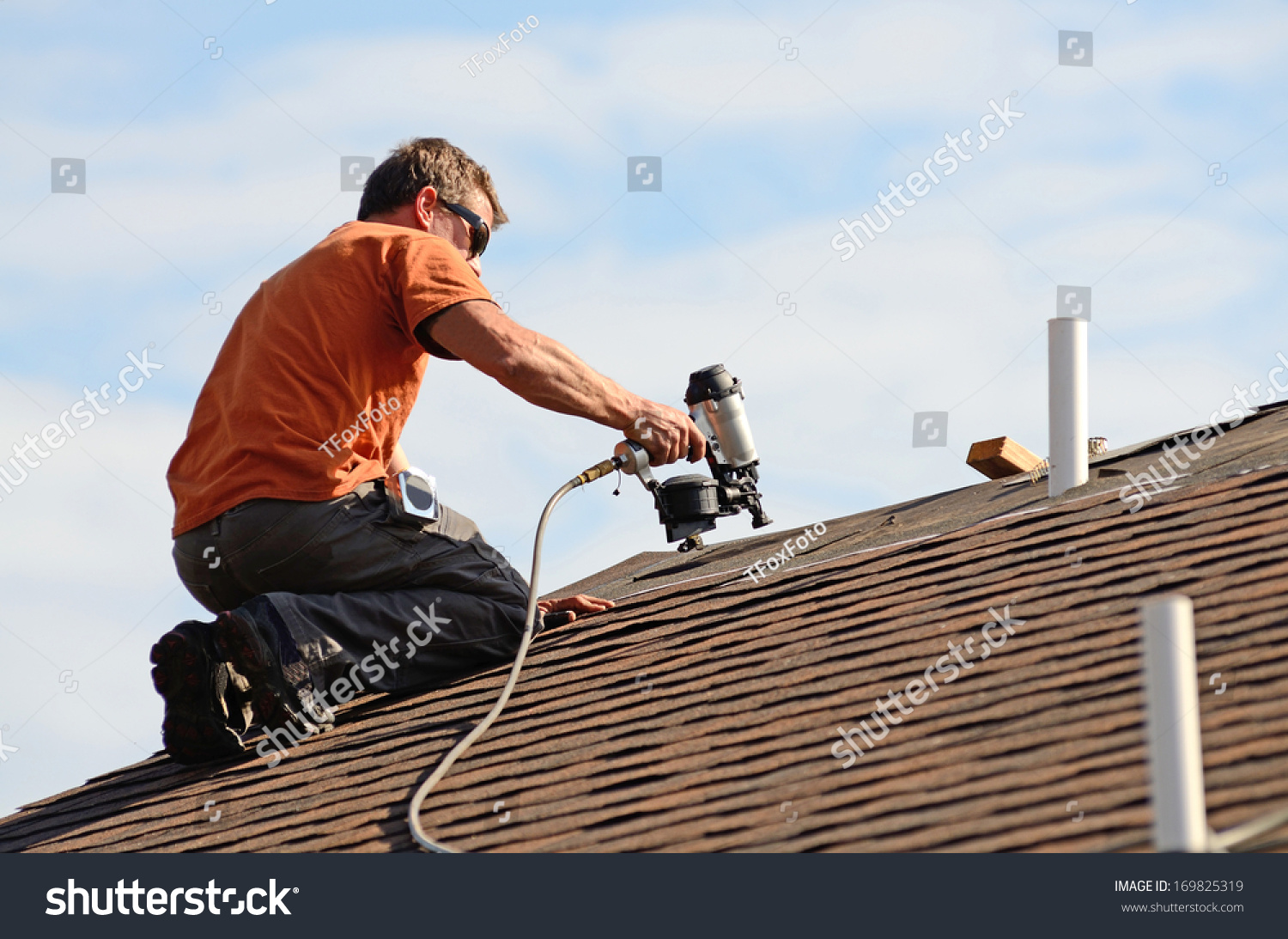 stock-photo-building-contractor-putting-the-asphalt-roofing-on-a-large-commercial-apartment-building-development-169825319.jpg