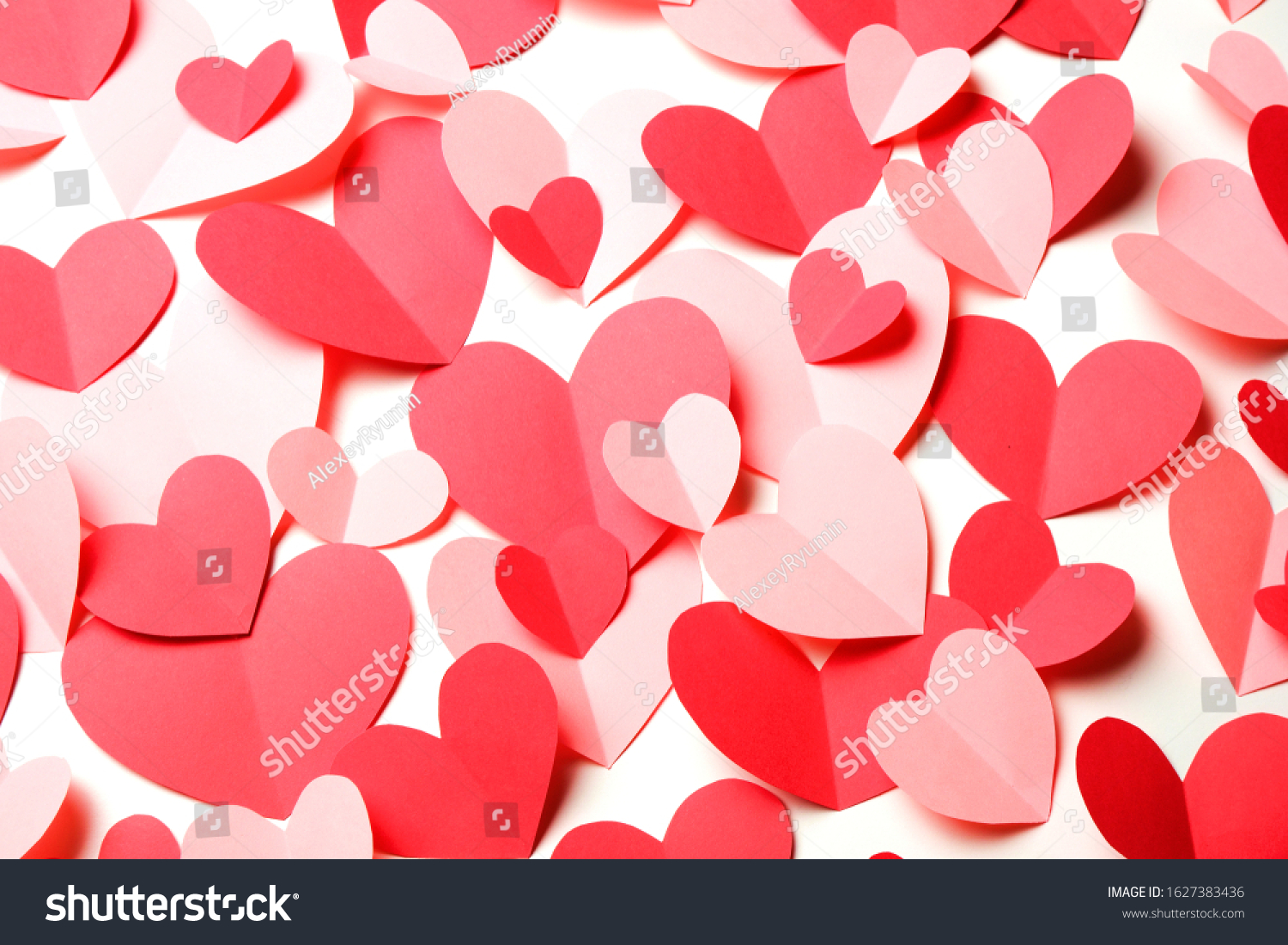 Bunch of cut out of pink and red paper hearts on white background closeup. Good Valentines day, Womans day, love, romantic or wedding card, banner, invitation background for banner, congratulation, card, offer, flyer, advertising, invitation.