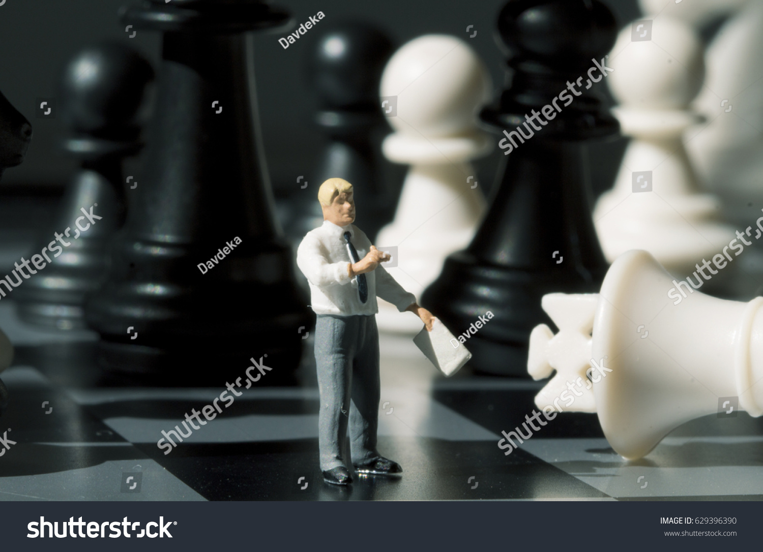 Businessman And Chess Figures On Game Board Playing With Miniature Doll Macro Photo Businessman And Chess Figures On Game Board Playing With Miniature Doll Macro Photo