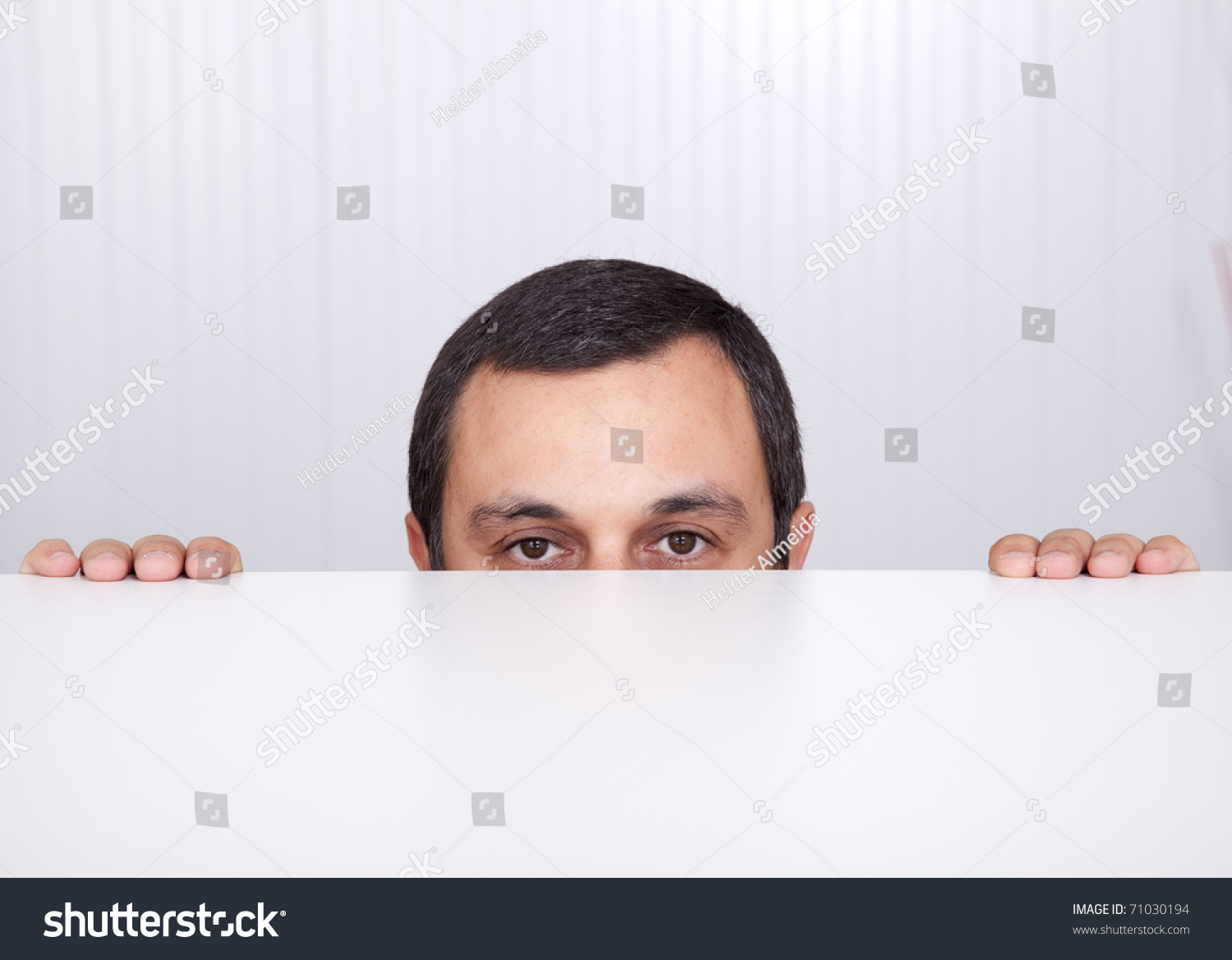 Businessman Peeking Behind The Desk And Looking To The Camera Stock ...