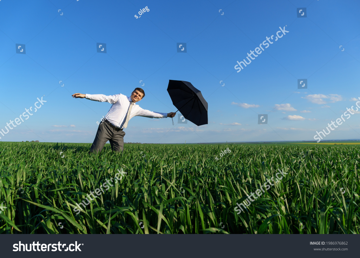 Businessman Poses Umbrella Field Hes Falling Stock Photo 1986976862 ...