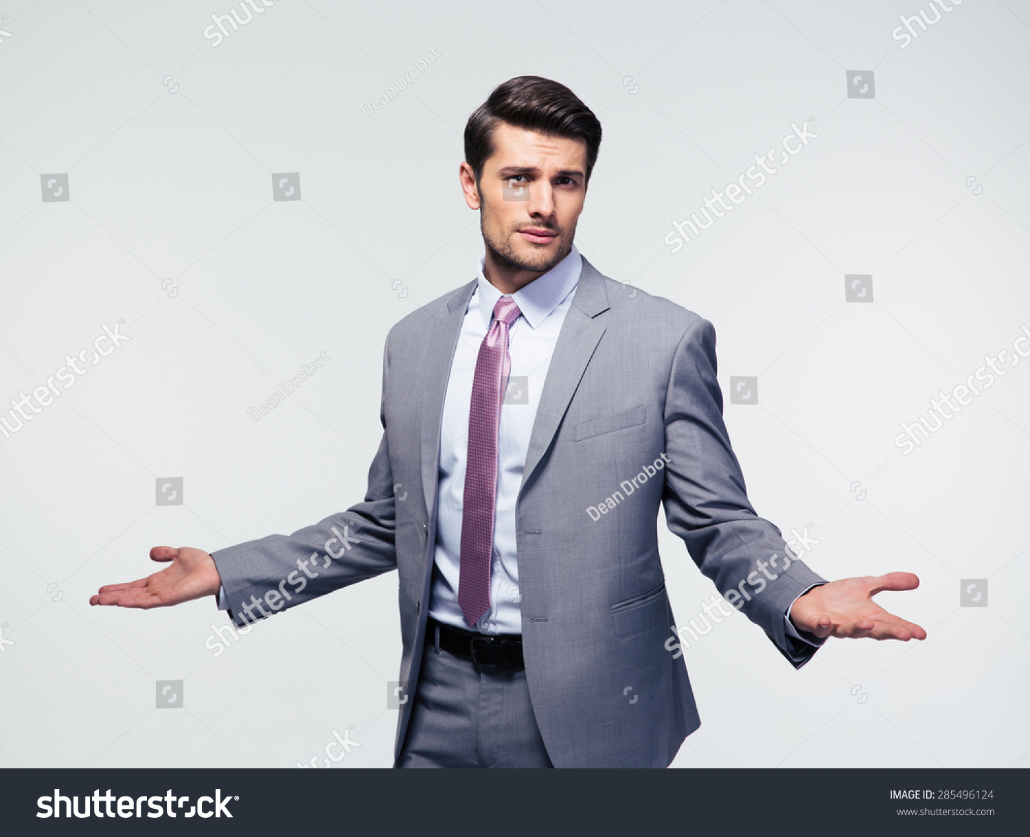 Businessman Shrugging Shoulders Over Gray Background Stock Photo ...