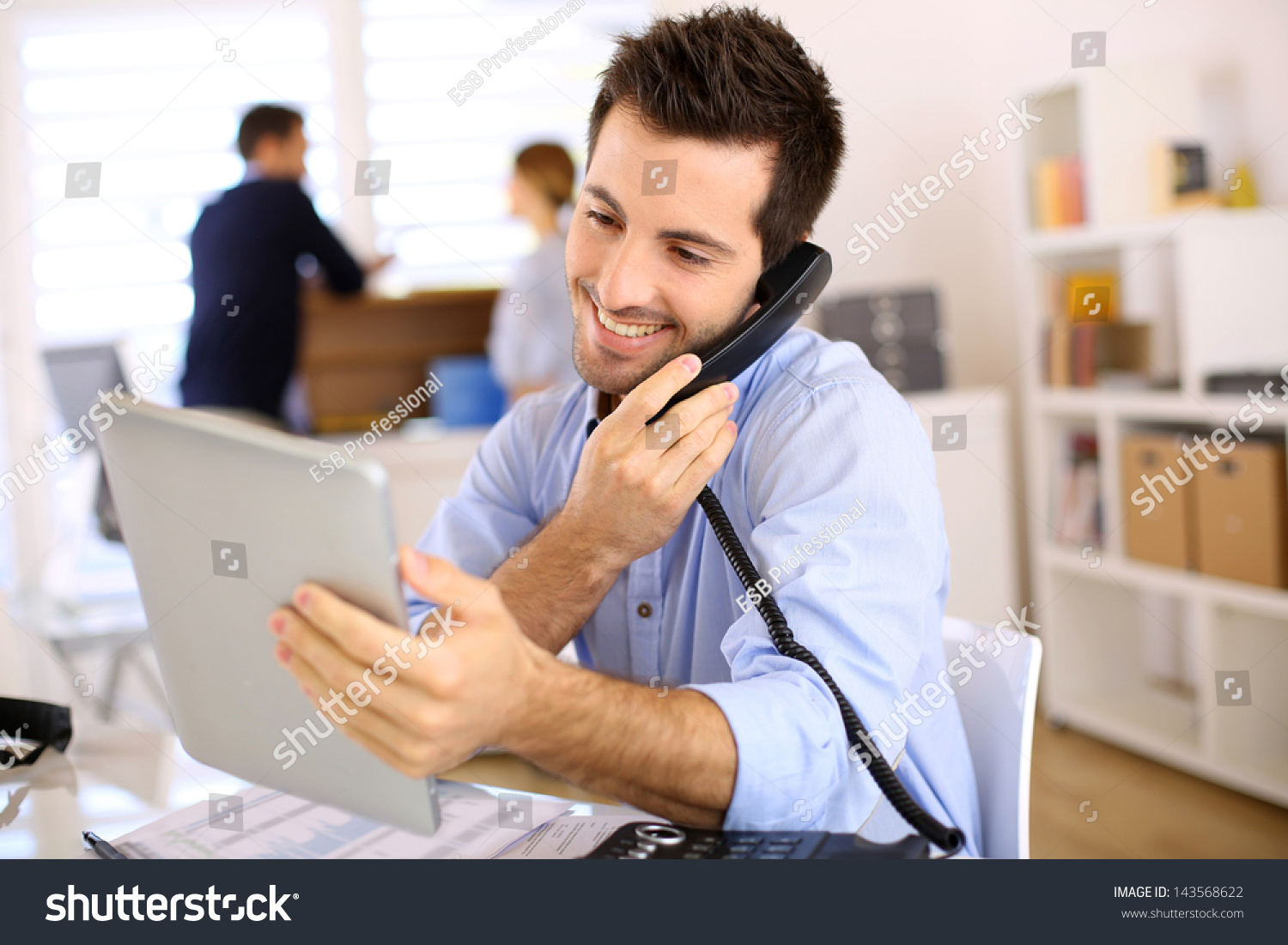 Cheerful man in office answering the phone