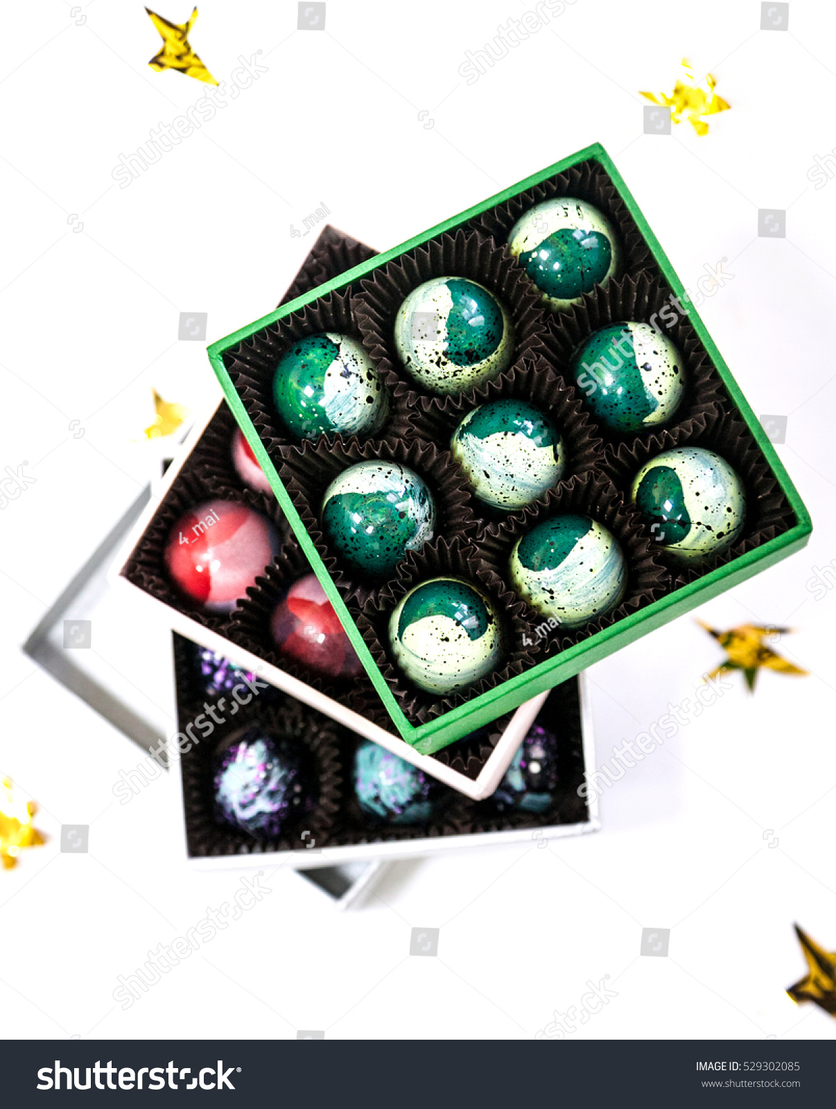stock photo chocolate handpainted luxury candy bonbons in a gift box white background with golden stars 529302085