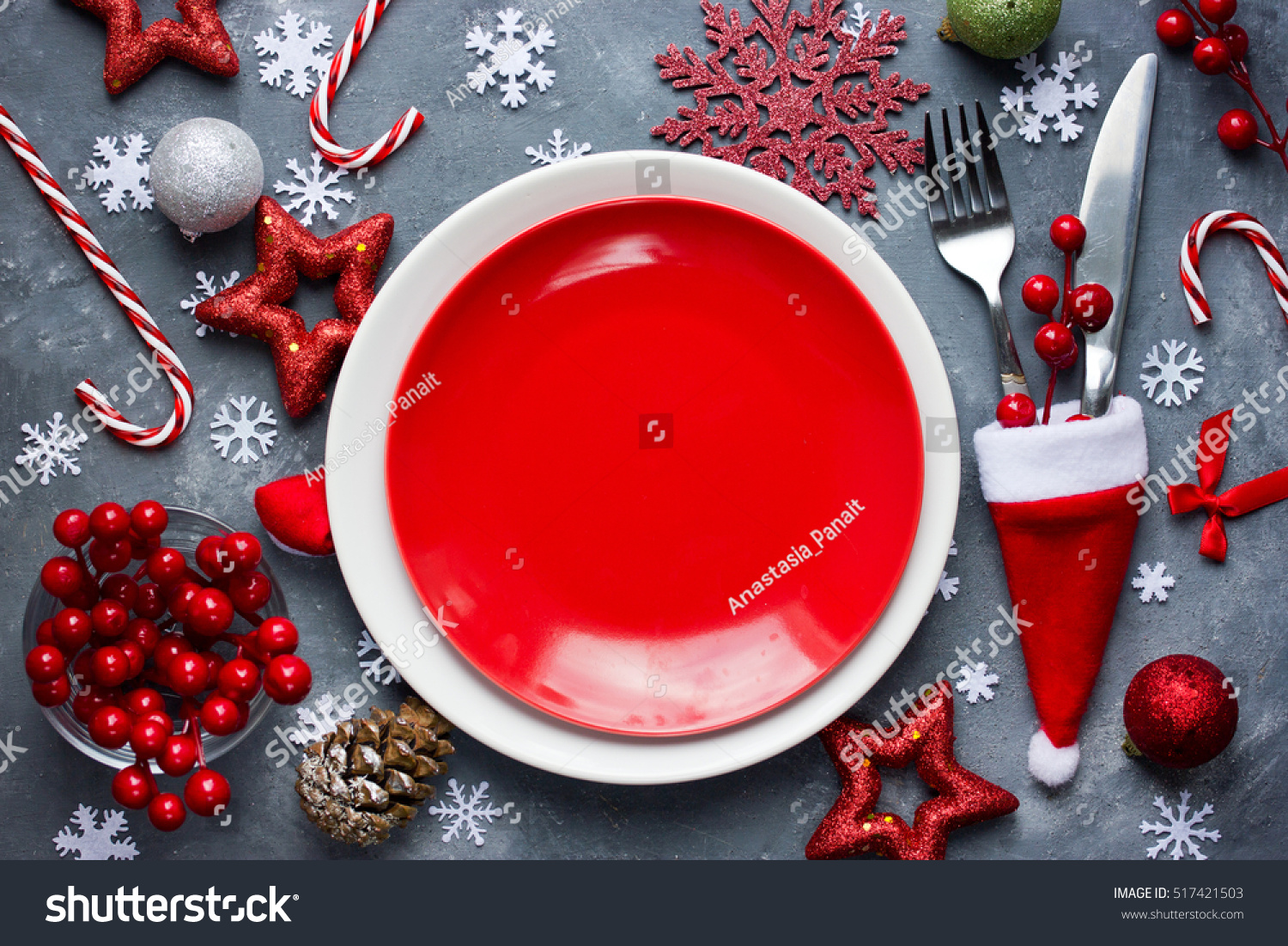 christmas table place setting with empty red plate cutlery in santa hat with festive decorations - Candy Cane Christmas Table Decorations christmas table place setting with empty red plate cutlery in santa hat with festive decorations - Candy Cane Christmas Table Decorations