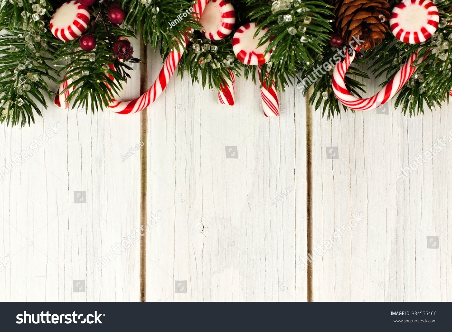 Christmas Top Border Of Branches And Candy Canes Against A White Wood ...