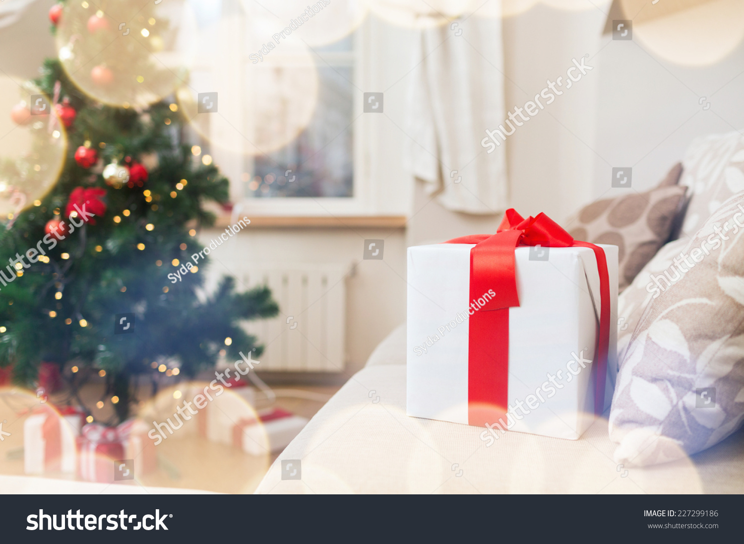 Christmas, X-Mas, Holidays, Winter And Happiness Concept - Gift Box On Coach At Home Stock Photo