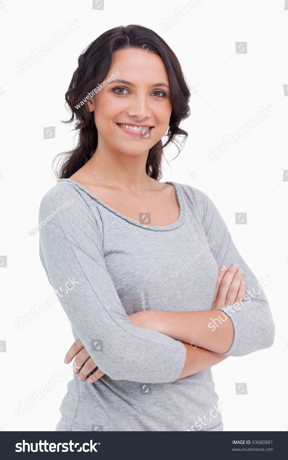 Close Up Of Smiling Young Woman With Her Arms Folded Against A White ...