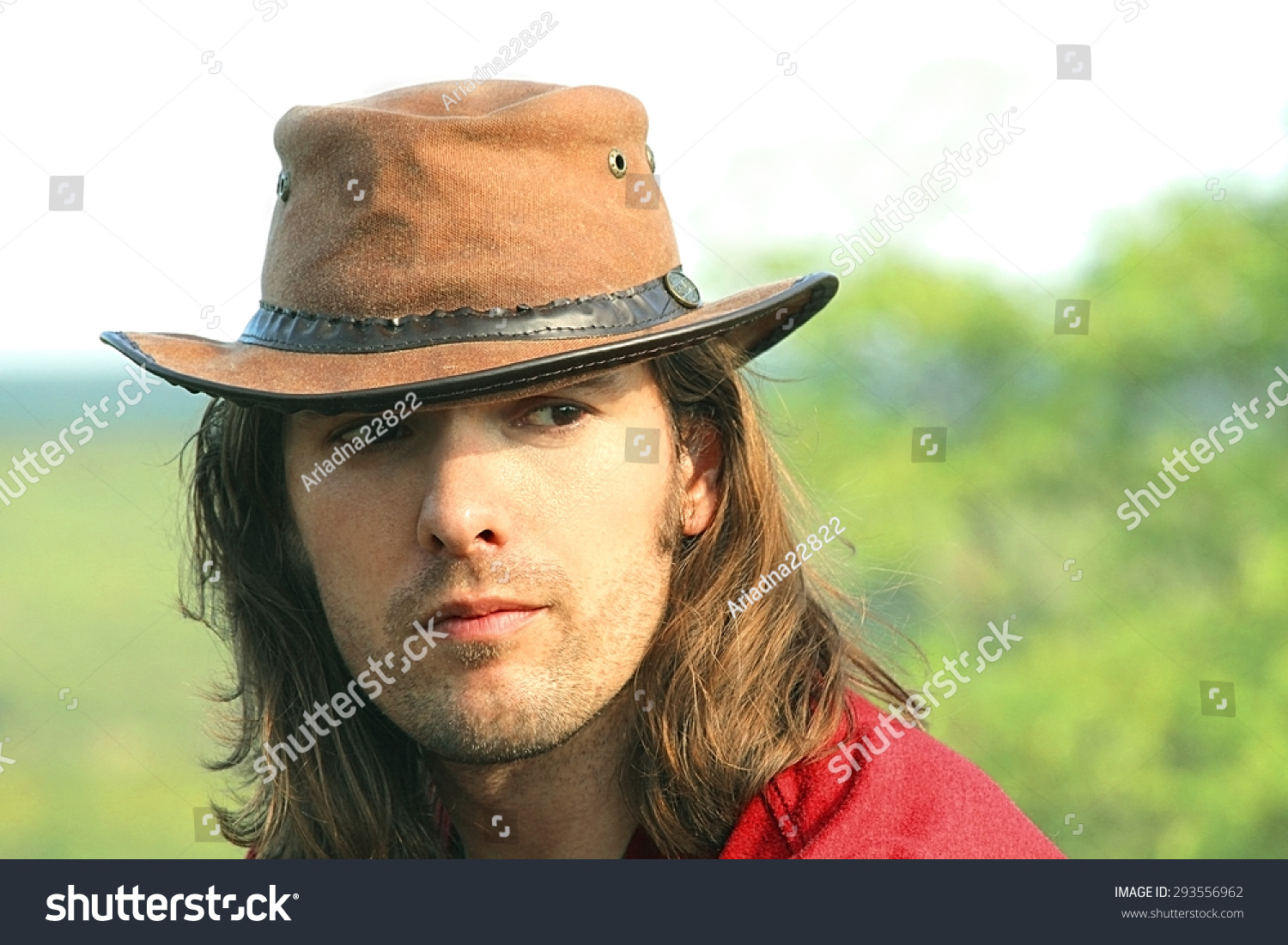 Close-Up Portrait Of Guy With Long Hair In Cowboy Hat. Style Safari