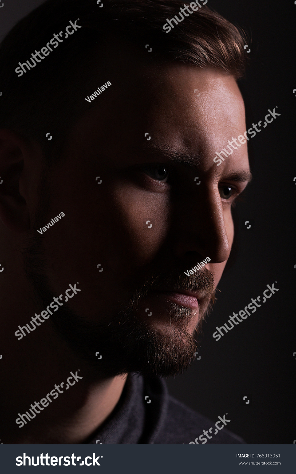 Color portrait of a young and handsome guy with light scheme rembrandt