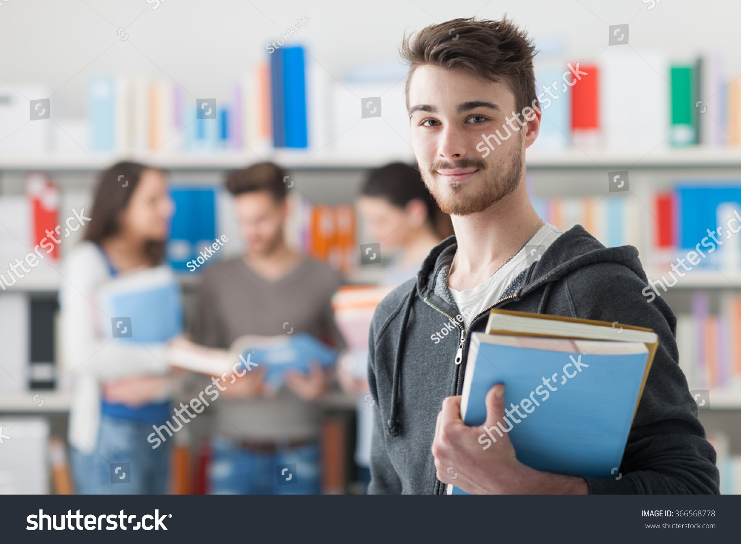 Confident Handsome Student Holding Books Smiling Stock