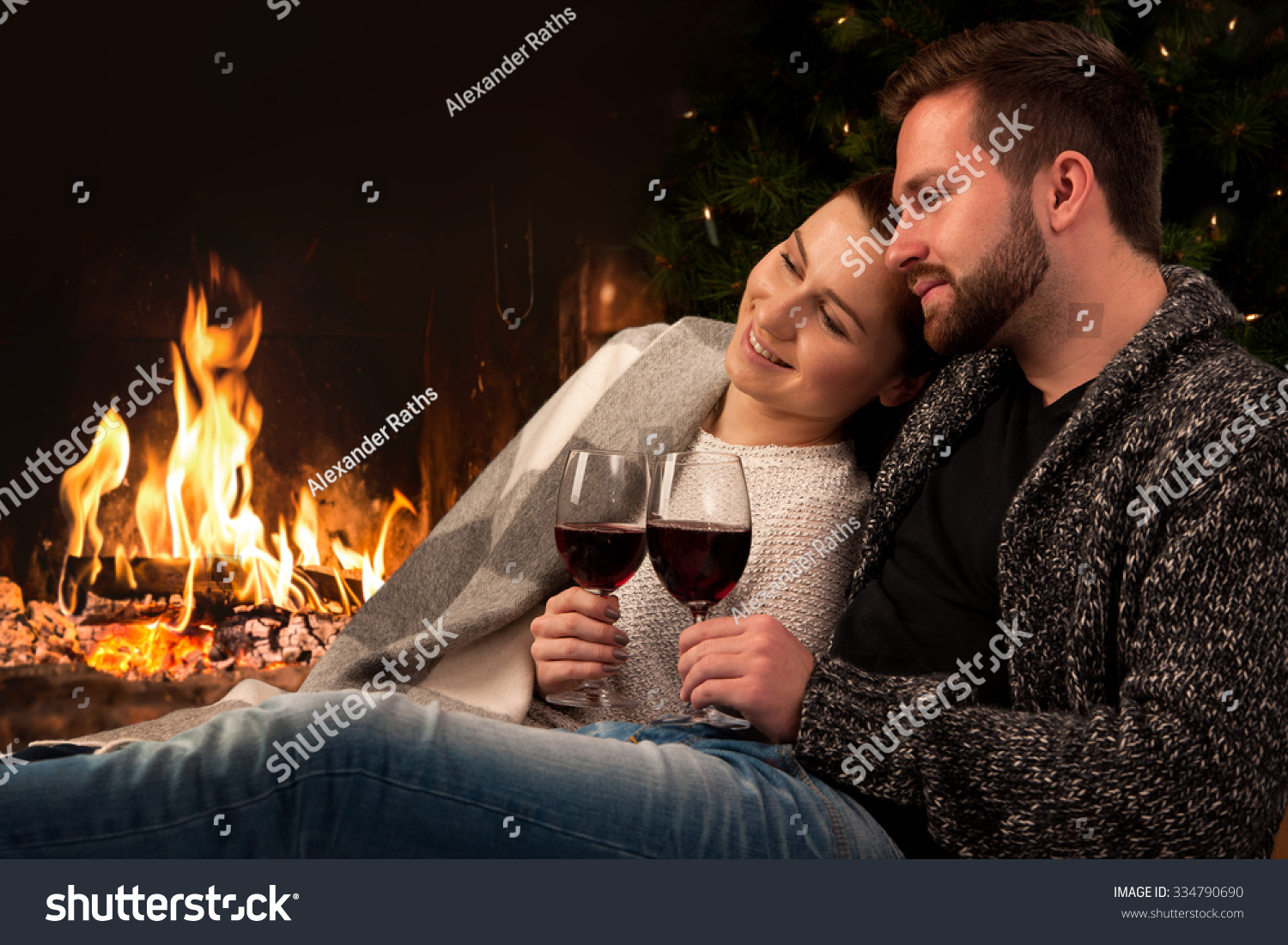 Couple Relaxing With Glass Of Wine At Romantic Fireplace On Winter ...