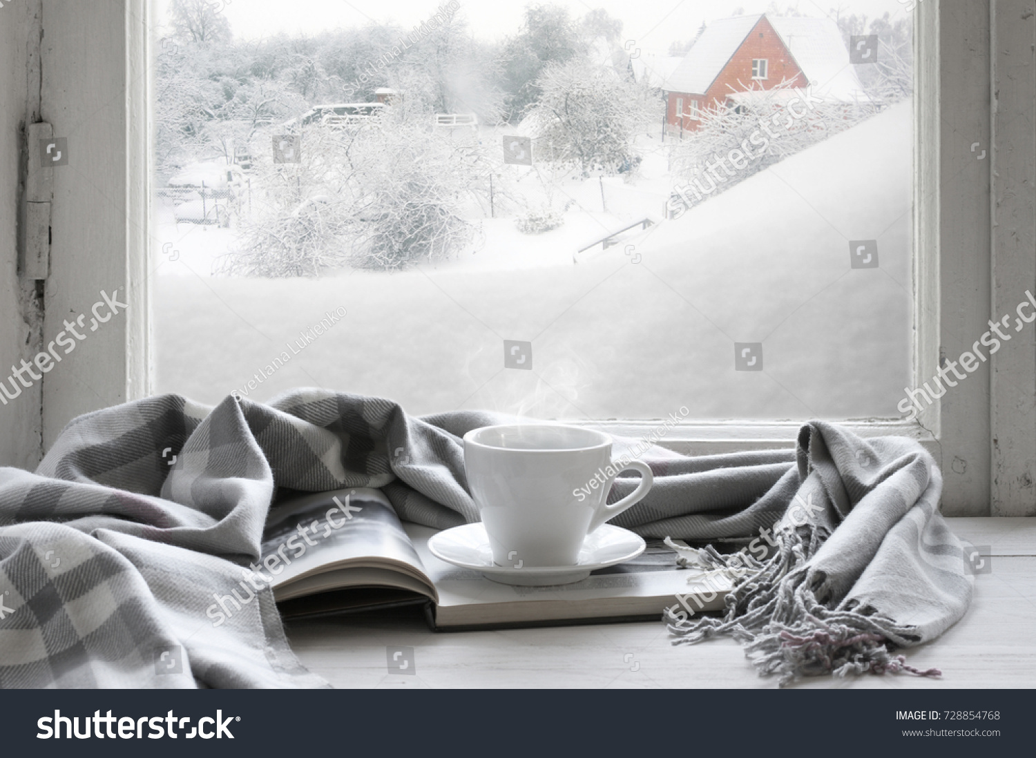 こぢんまりした冬の静寂 熱いコーヒーを1杯飲み 外から吹雪の降る雪景色の背景に ビンテージの窓の下枠に暖かい格子と本を開けた の写真素材 今すぐ編集