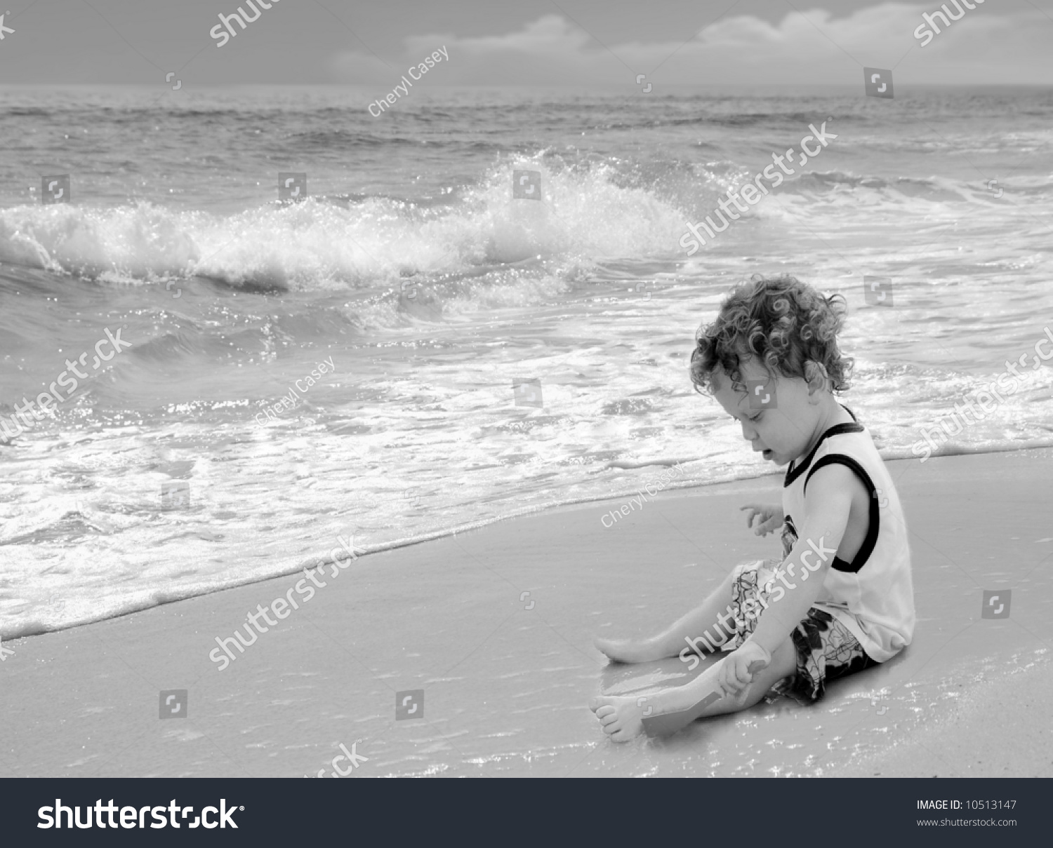 Cute Curly Headed Boy Playing With Sand On Pretty Beach Stock Photo ...