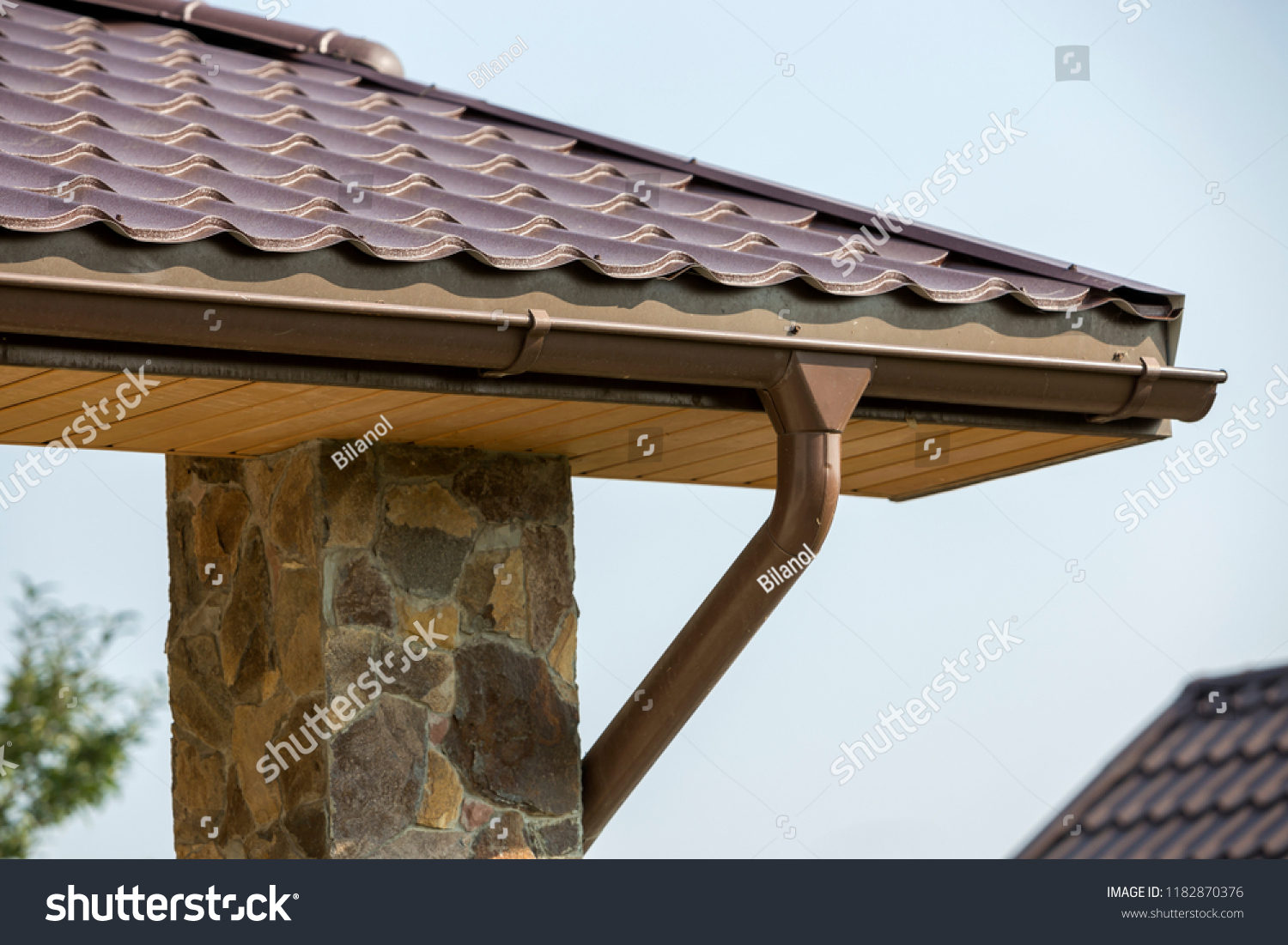 Detail of new modern house cottage corner with stucco walls decorated with natural stones brown