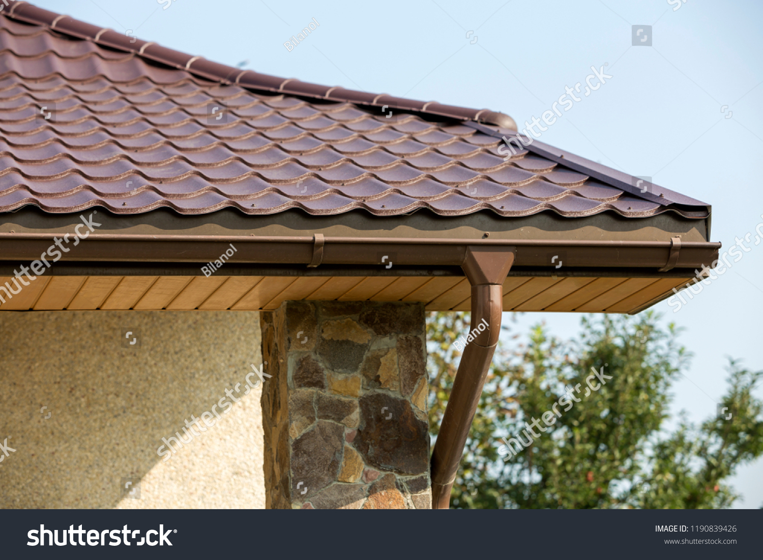 Detail of new modern house cottage corner with stucco walls decorated with natural stones brown