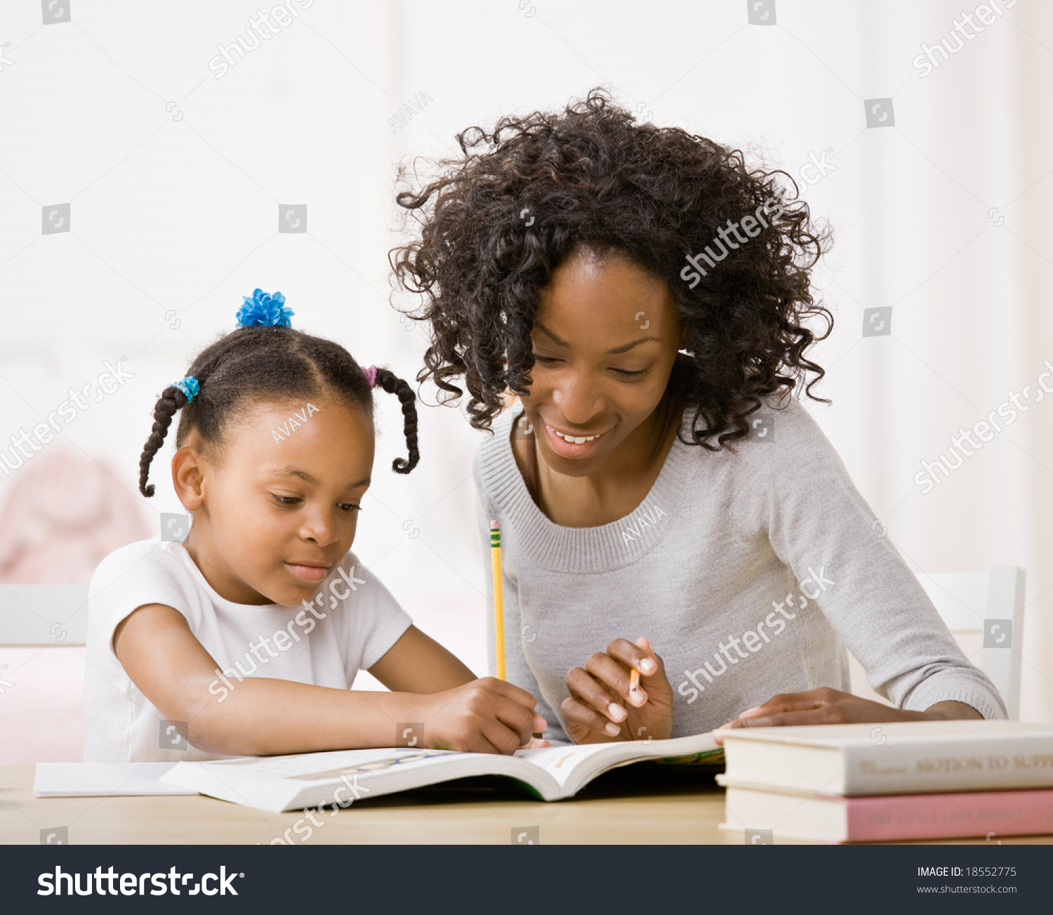 Devoted Mother Helping Daughter Do Homework In Workbook Stock Photo ...