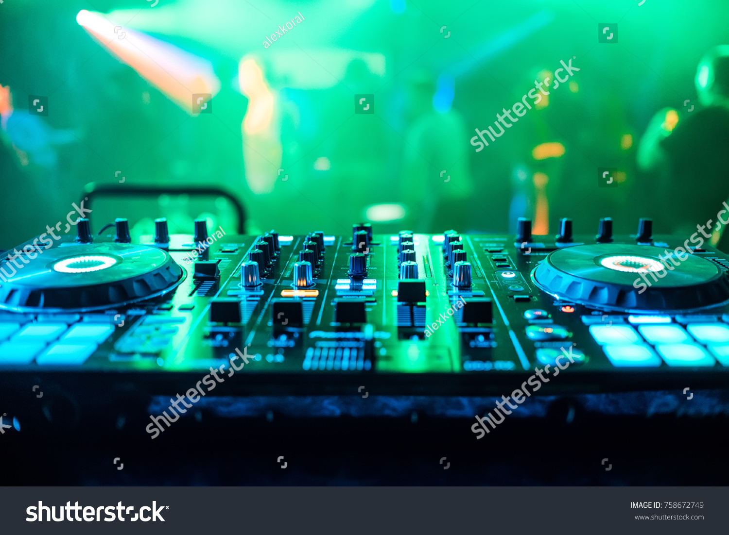 DJ Booth At Night Club Party For Music Mixing With Green Blurred Background DJ Booth At Night Club Party For Music Mixing With Green Blurred Background