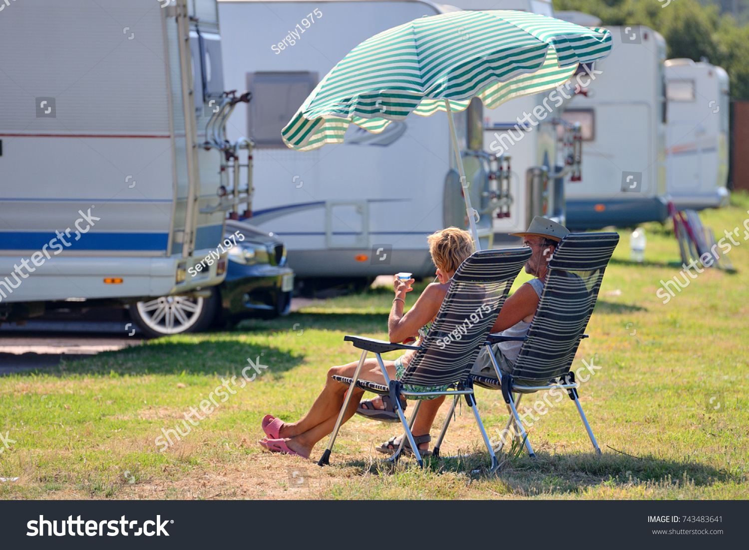 Elderly Couple Resting On Chairs Under People Holidays Stock Image