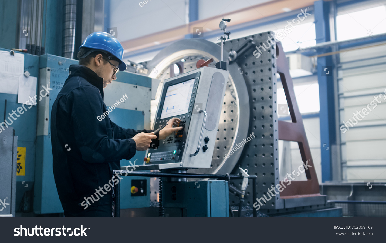 工場労働者は タブレットコンピュータを使用してcnc製粉機をプログラミングしています の写真素材 今すぐ編集