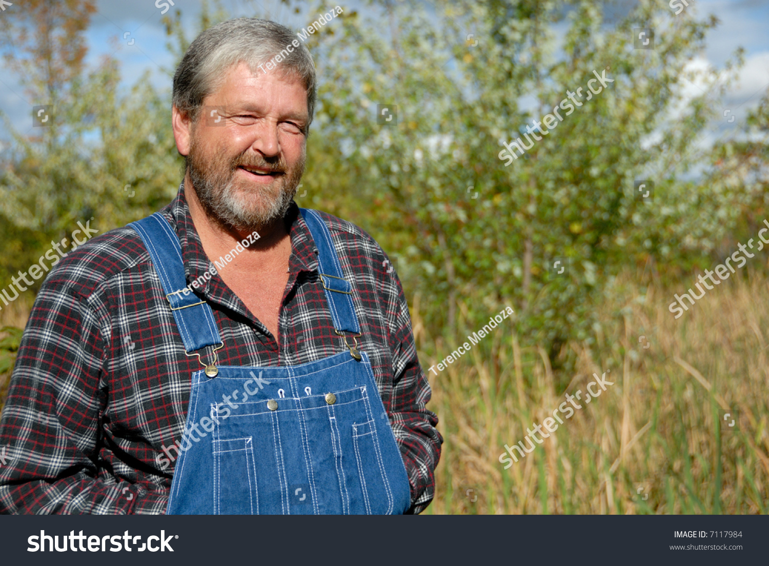 Farmer Smiling In Plaid Shirt & Bib Overalls Stock Photo 7117984 ...