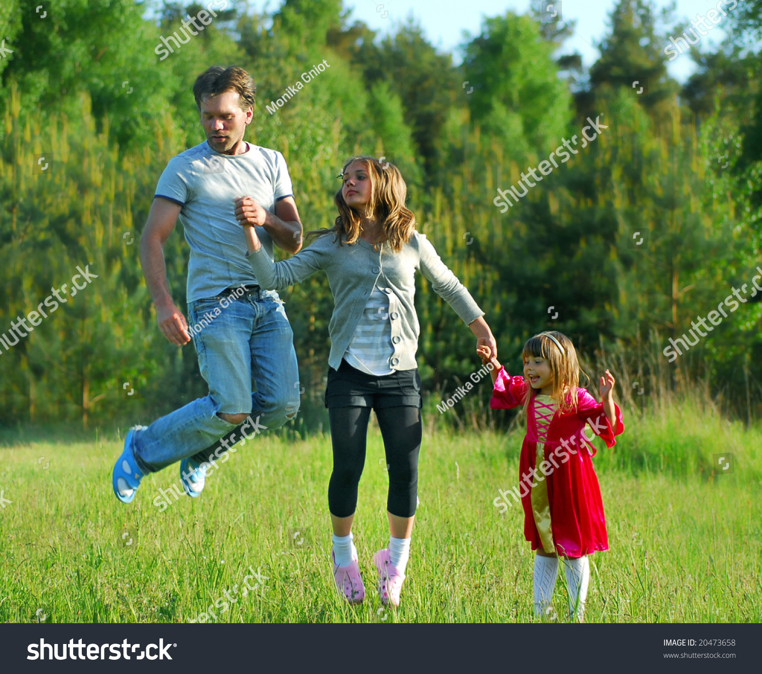 Father His Children Jumping On Meadow Stock Photo 20473658 - Shutterstock