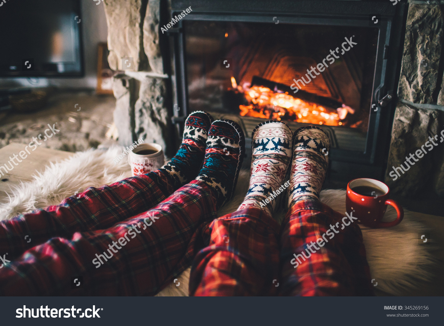 Feet In Woollen Socks By The Christmas Fireplace. Couple Sitting Under ...