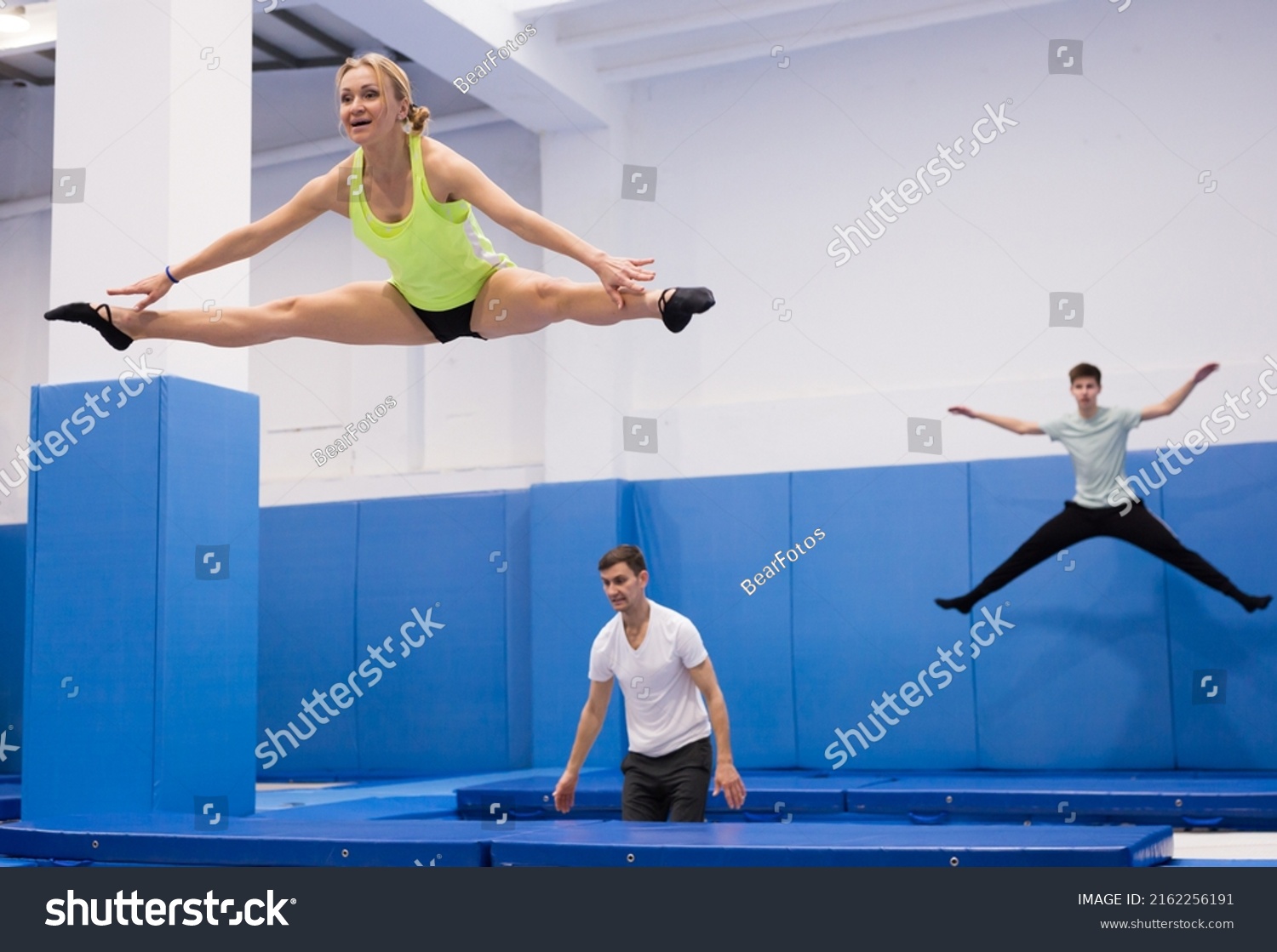 Female Gymnast Jumping On Professional Trampoline Stock Photo ...