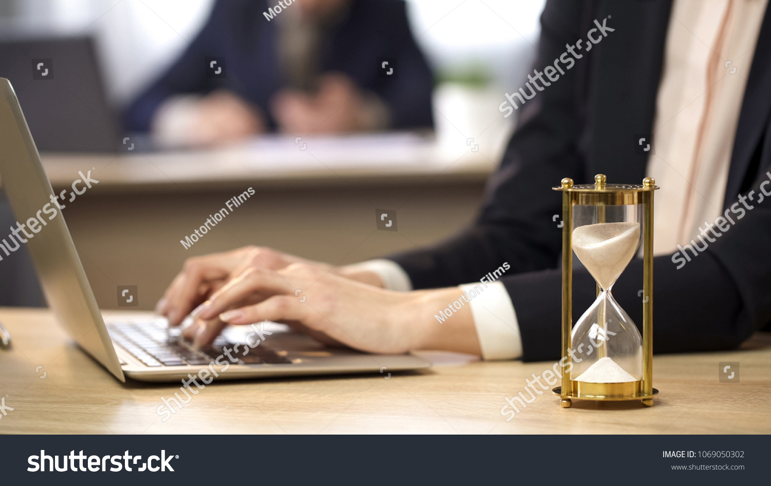 オフィスでノートパソコンを使用する女性 時間を計測する砂時計 仕事の効率性 動画素材 の写真素材 今すぐ編集