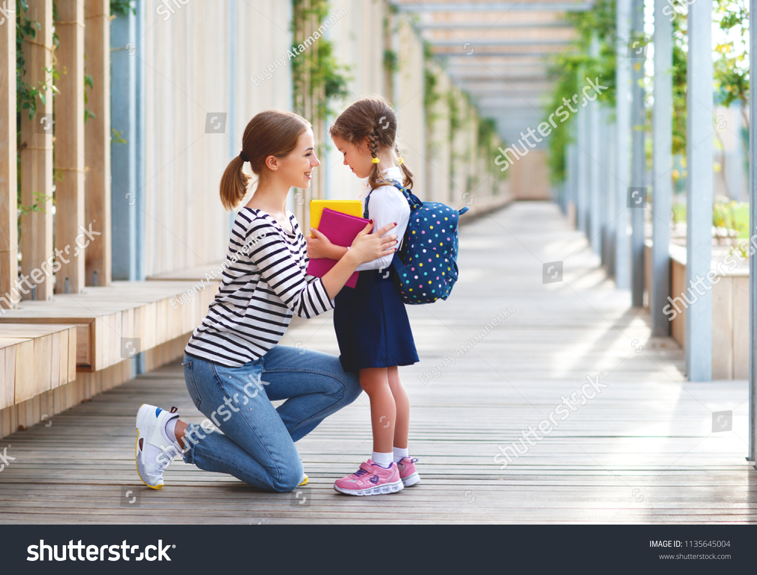 学校の初日 母親は小さな小学1年生の女の子を指導する の写真素材