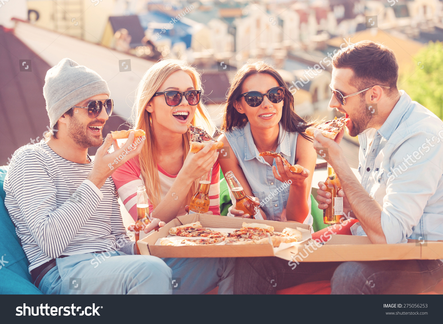 Friends And Pizza. Four Young Cheerful People Eating Pizza And Drinking ...