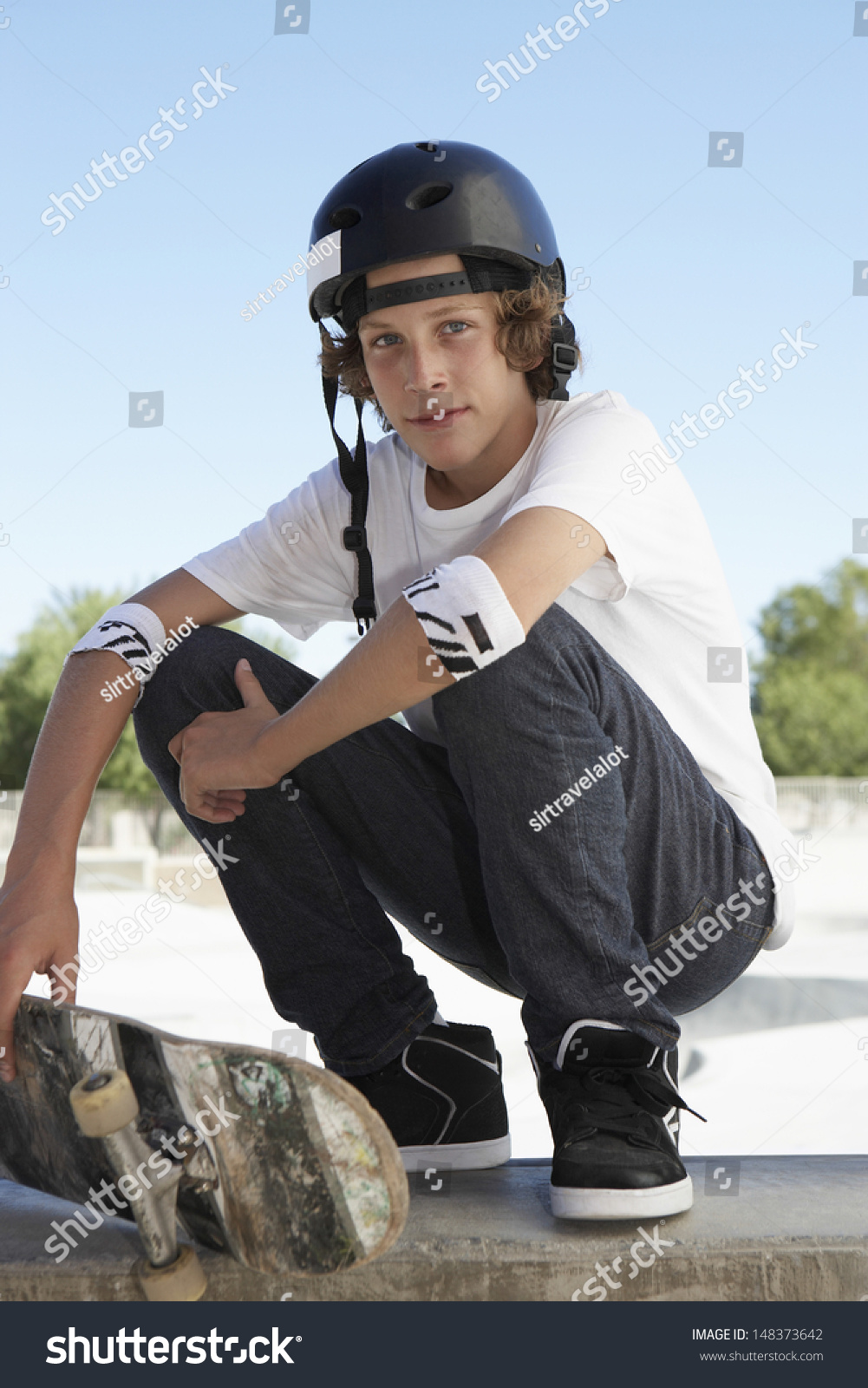 Full Length Portrait Of Teenage Boy With Skateboard Crouching In Skate ...