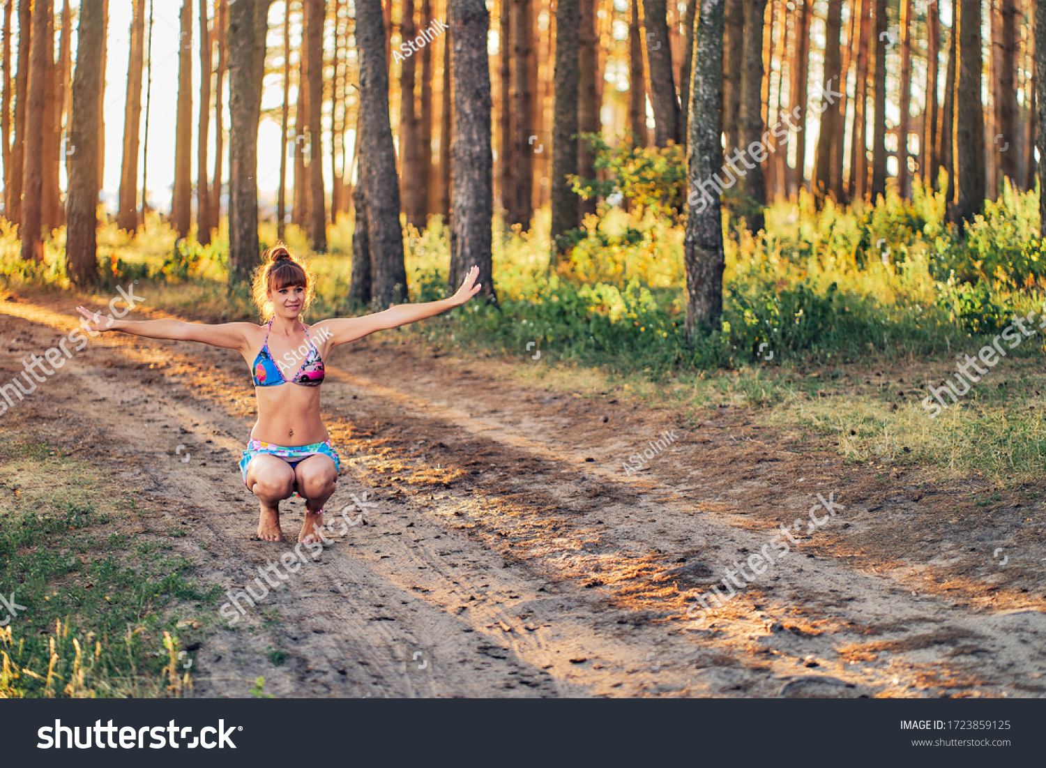 https://image.shutterstock.com/z/stock-photo-girl-in-a-bathing-suit-and-short-skirt-is-training-in-the-forest-1723859125.jpg