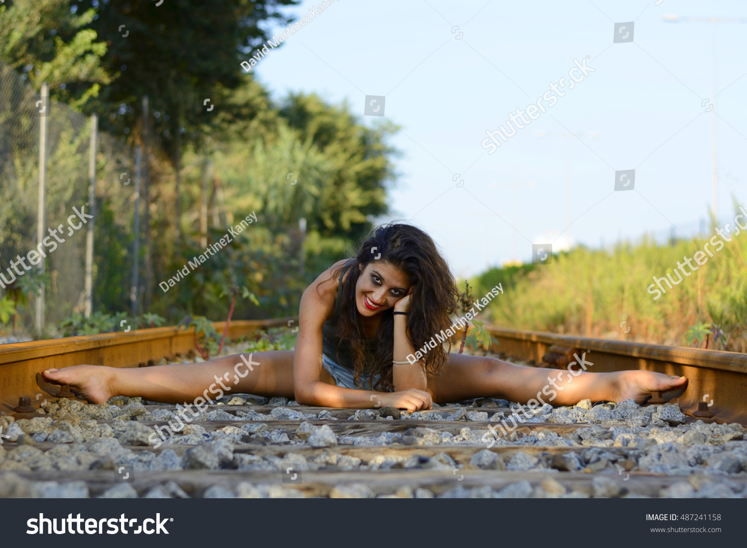 https://image.shutterstock.com/z/stock-photo-girl-sitting-with-her-legs-spread-on-train-tracks-487241158.jpg