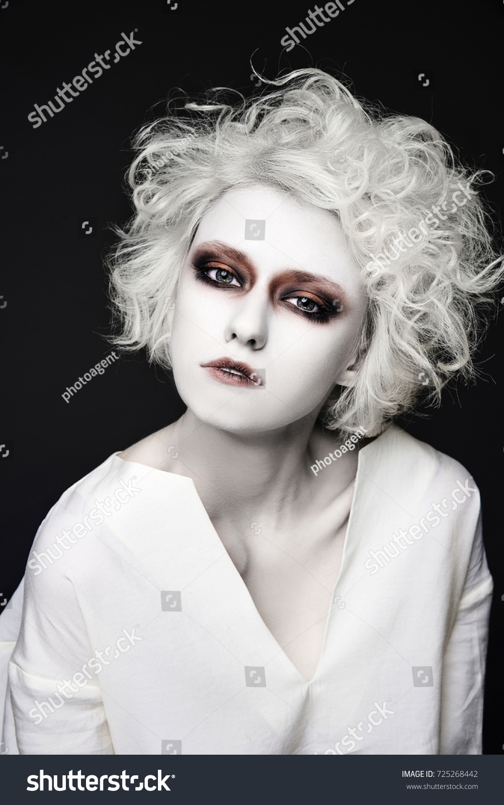 stock photo girl with scary clown make up for halloween blond young woman with white skin psycho person for 725268442
