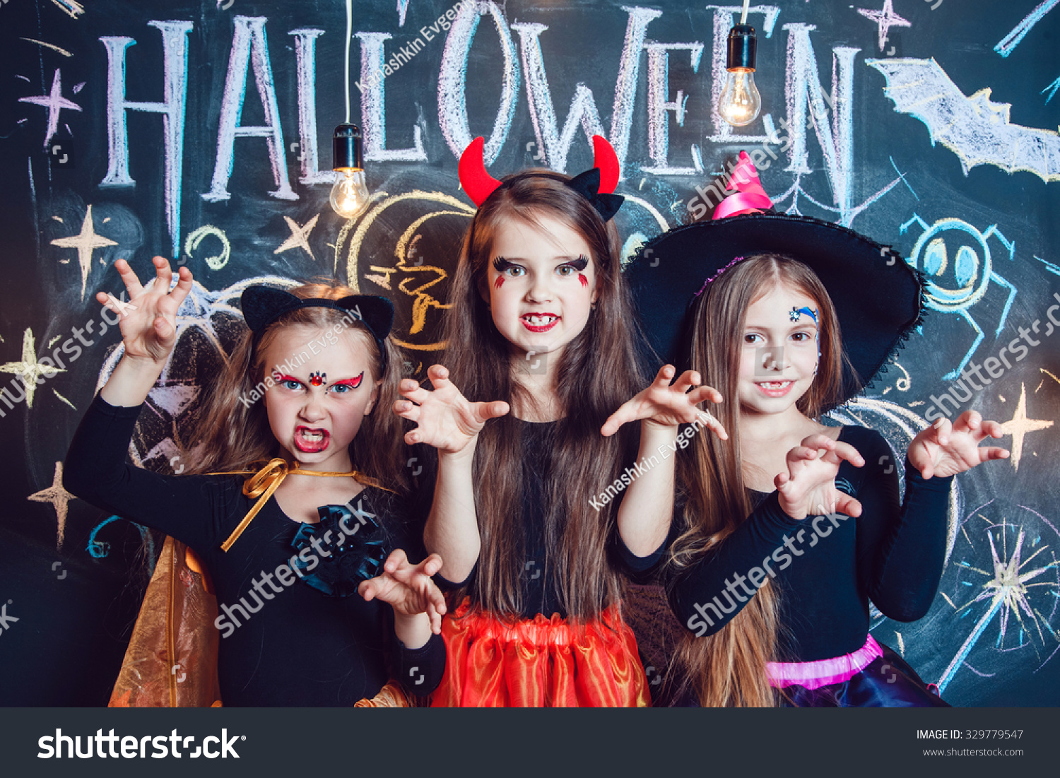 Girls, Dressed Up In Halloween Costumes, Show Emotions Of Witches ...