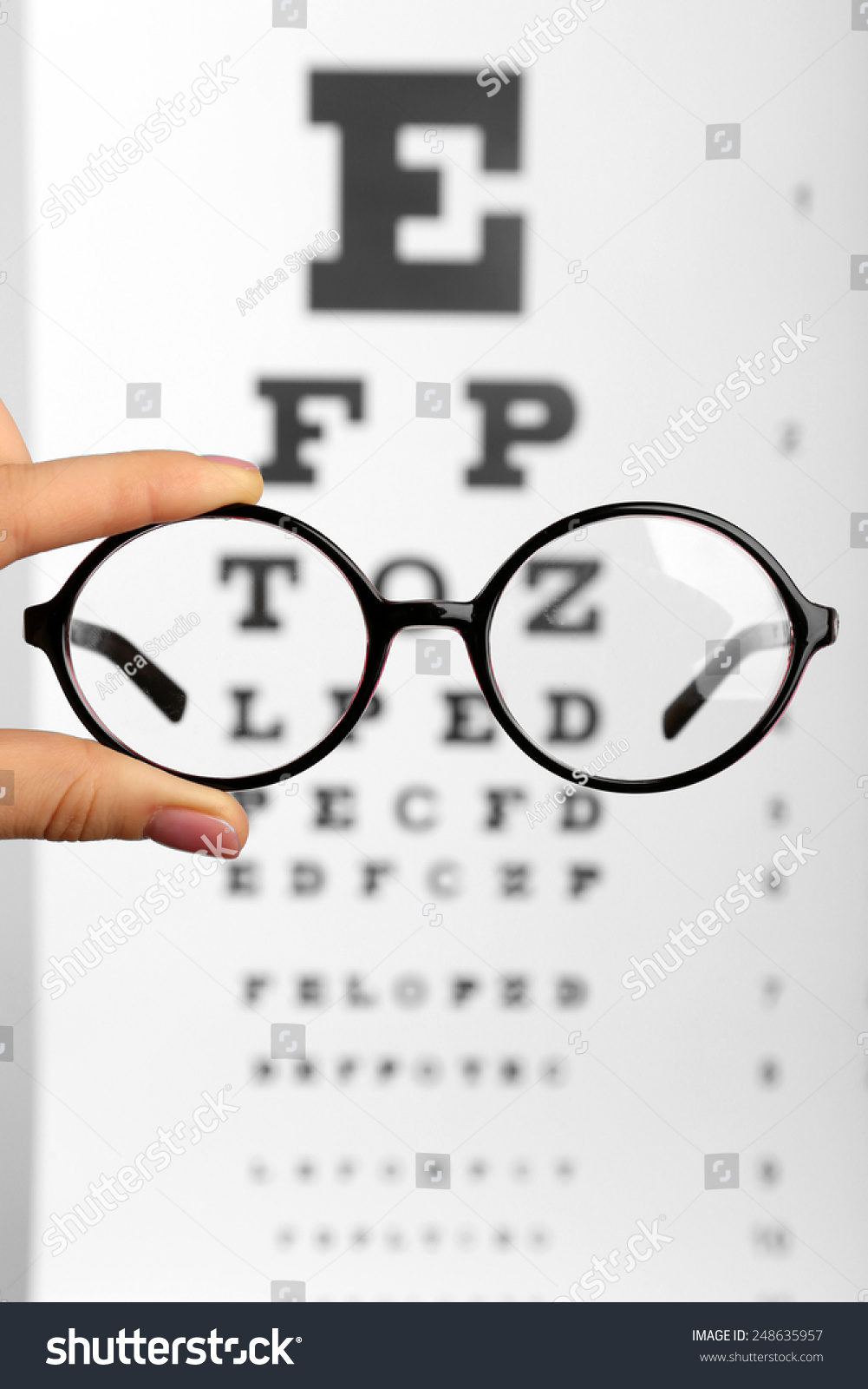 glasses-hands-on-eye-chart-background-foto-stok-248635957-shutterstock