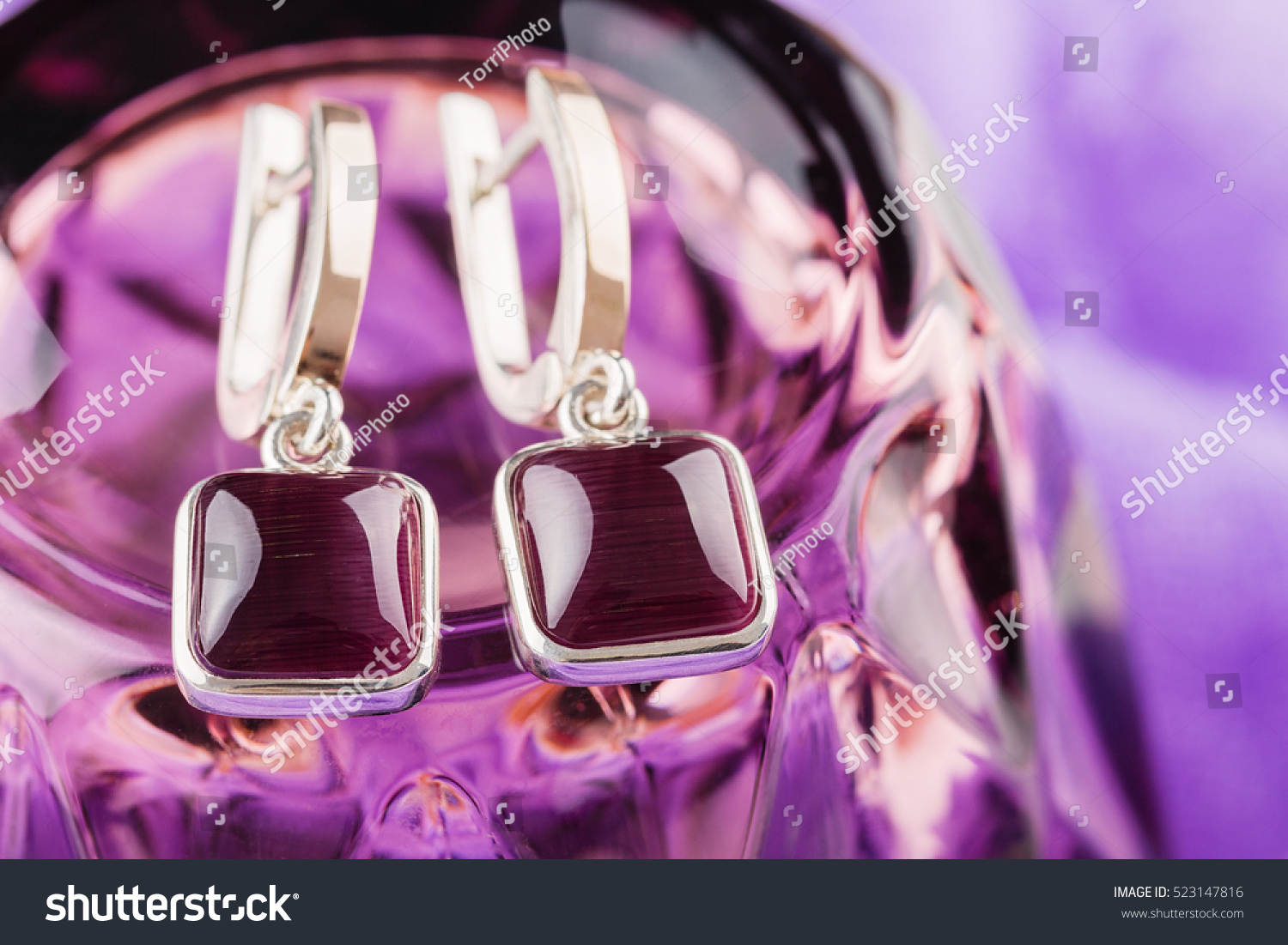 https://www.shutterstock.com/pic-523147816/stock-photo-gold-ring-square-shaped-with-purple-gemstones-on-violet-background.html