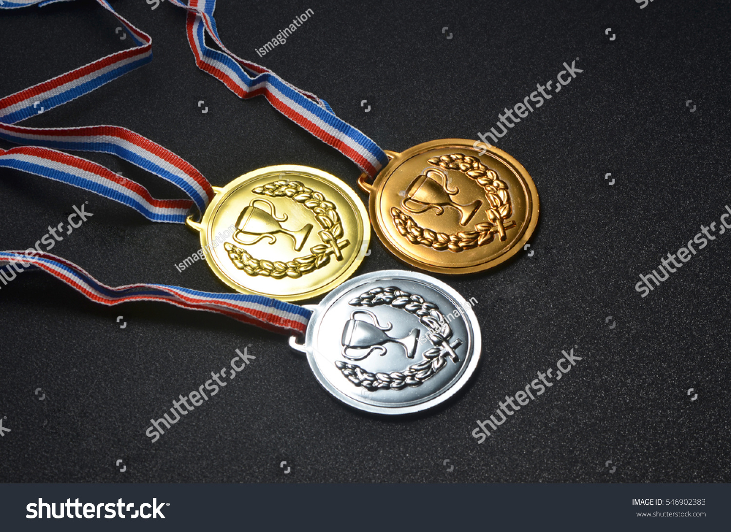 Gold, silver and bronze medals on top of black board