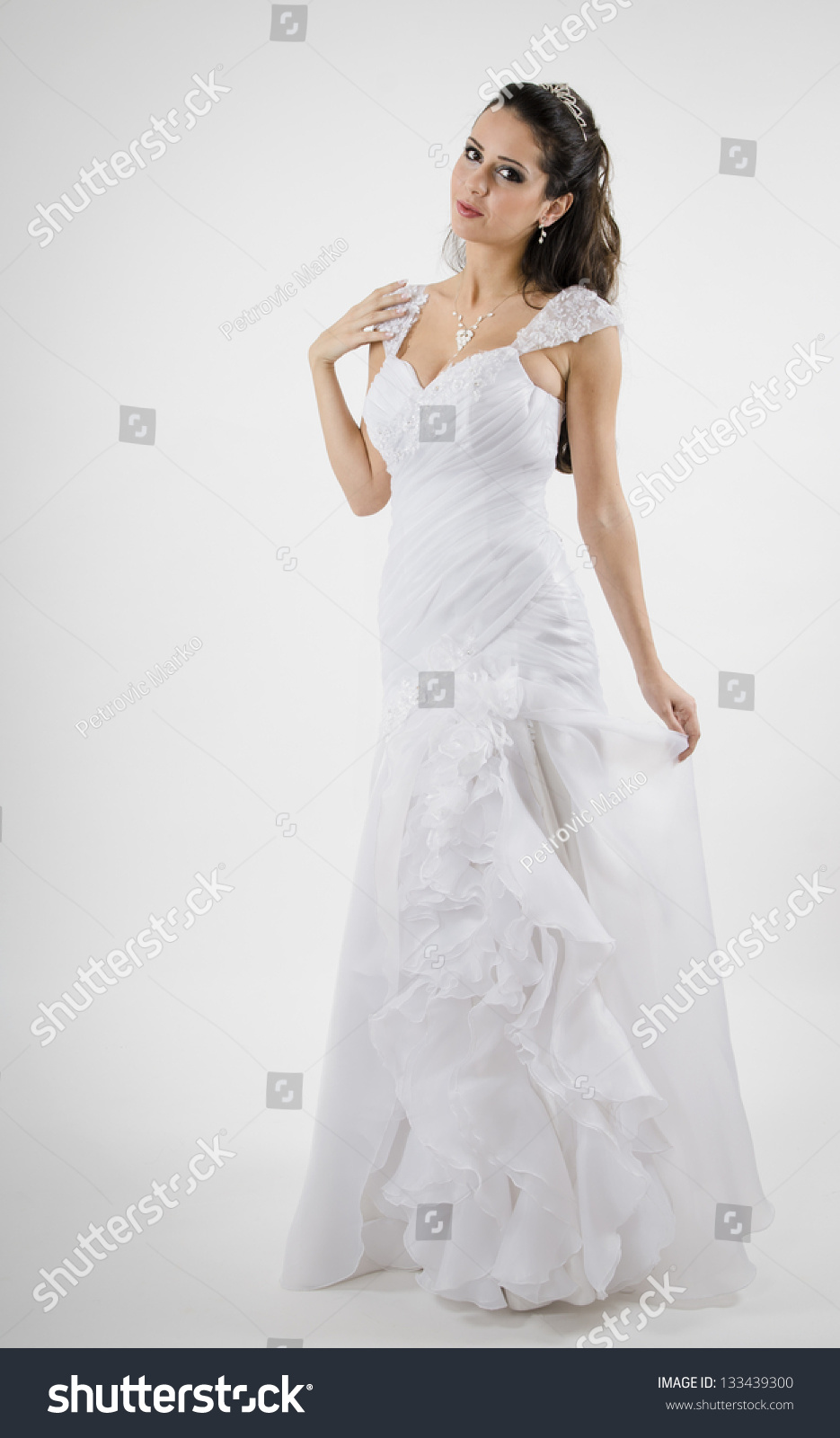 Gorgeous Bride In Wedding Dress Standing And Holding Dress With One ...