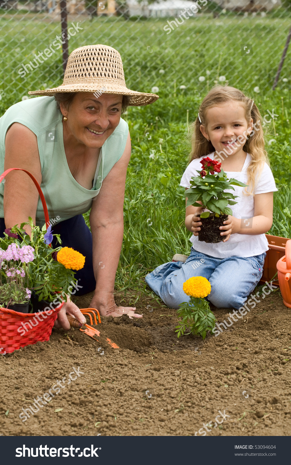 Grandmother Teaching Little Girl Gardening - Planting A Flower Together ...